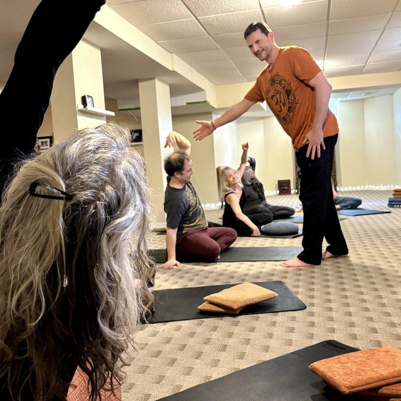 Students being guided by an instructor in a yoga class