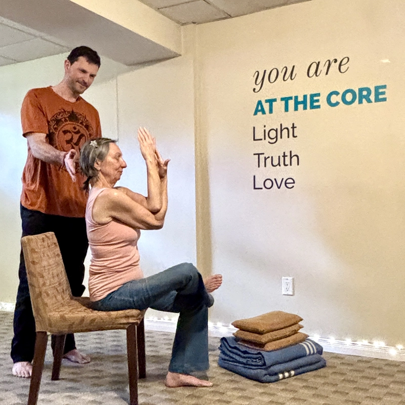 Yogesh correcting a student during a yoga class