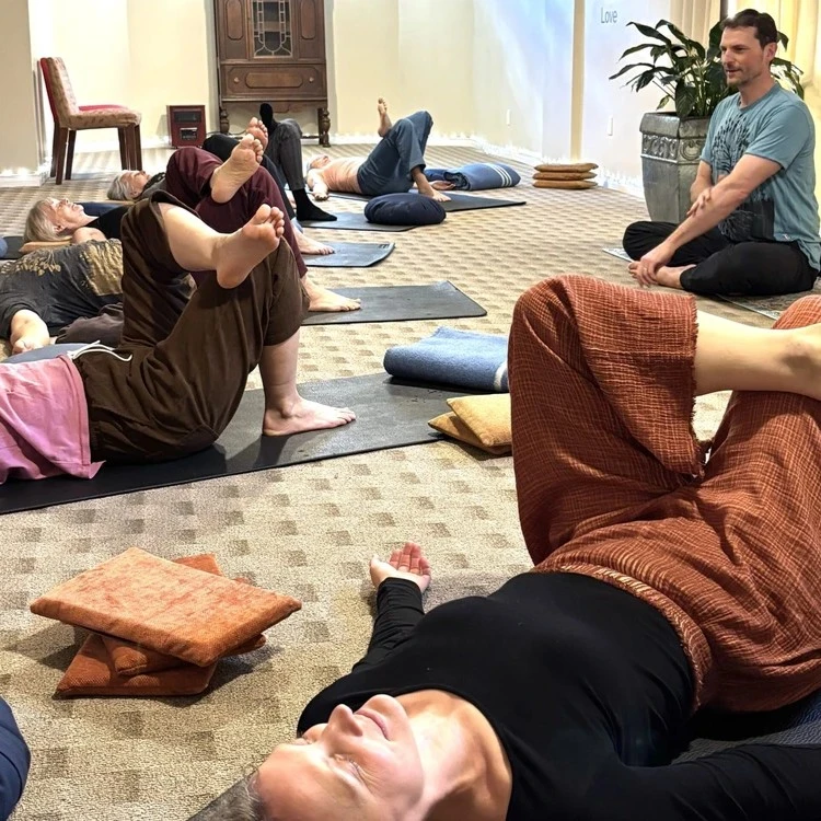 Yogesh guiding students as they hold a pose during a senior's yoga class