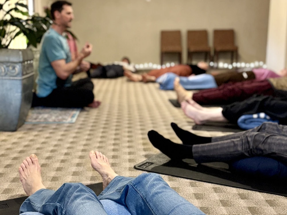 Instructor guiding students through a relaxing pose in a yoga class for seniors in London, ON