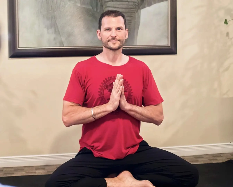 Seated gentle yoga pose with hands at heart centre at AT THE CORE studio in London, Ontario